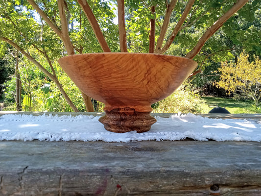 Wooden bowl on a wooden surface with a natural outdoor background